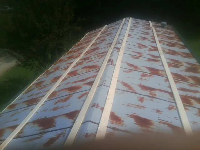 Rusted metal roof panels with new wood purlins before replacement — Storm Damage Roof Repair in Sardis by Roofing Brothers